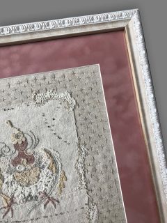 фрагмент вышивки в белой раме с бархатным паспарту